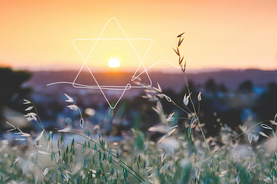 Photo of a sunrise over a field with white overlaying illustrated Star of David icon over the sun